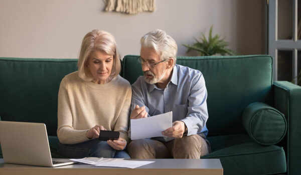 Serious mature couple calculating bills to pay Serious mature couple calculating bills to pay, checking domestic finances, middle aged family managing, planning budget, expenses, grey haired man and woman reading bank loan documents at home